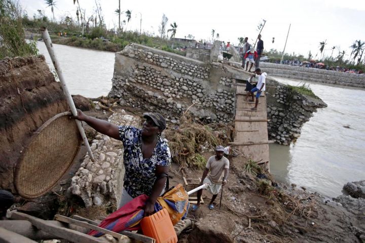 People use a handmade ladder after the bridge has been destroyed by Hurricane Matthew in Chantal, Haiti.