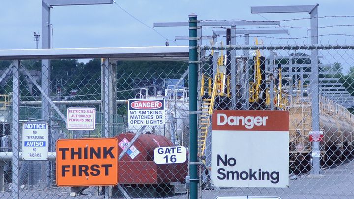 A medley of caution signs is posted on a barbed-wire fence near the Global Partners Albany Terminal, where crude oil from trains is offloaded for transport on the Hudson River. The oil's volatile nature has caused worries in Albany's South End.
