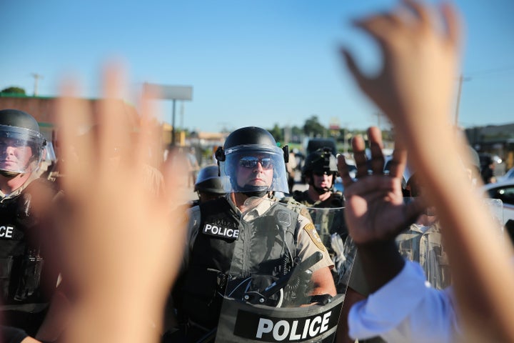 A child holds up her hands after police ordered protesters off the street on Aug. 13, 2014, in Ferguson, Missouri.