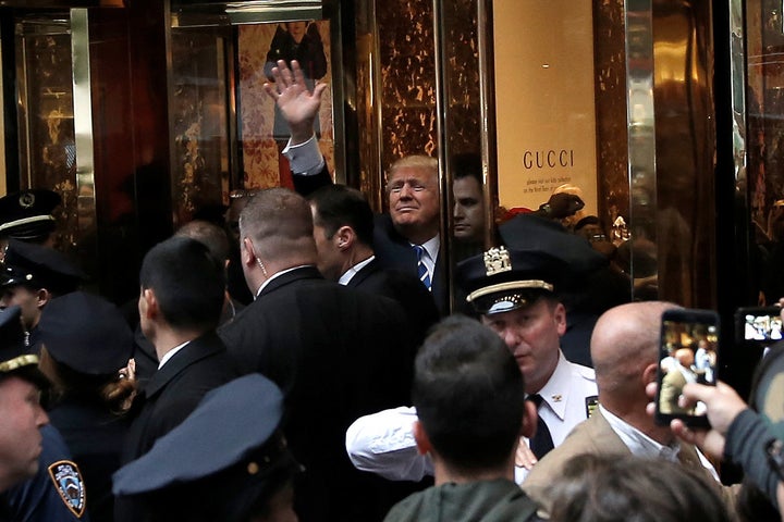 Republican presidential nominee Donald Trump waves to supporters outside the front door of Trump Tower where he lives in the