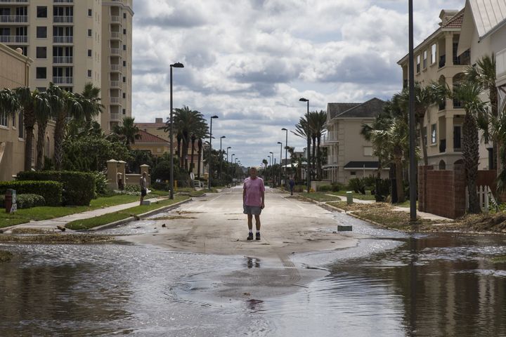 A man stands at the edge of a flooded street after Hurricane Matthew passed along Jacksonville, Florida, on Oct. 8, 2016.