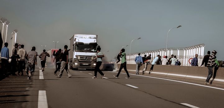 An Eritrean migrant was killed and his wife was injured near Calais after being struck by a car as dozens of refugees tried to board passing trucks; a scene from Calais last month is pictured above