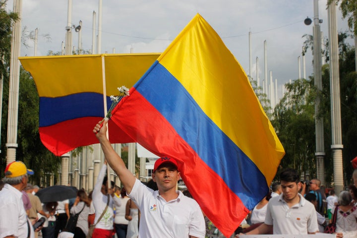 Pro-peace supporter waves the Colombian flag as he joins thousands of others in the Park of Lights in downtown Medellín on October 7.