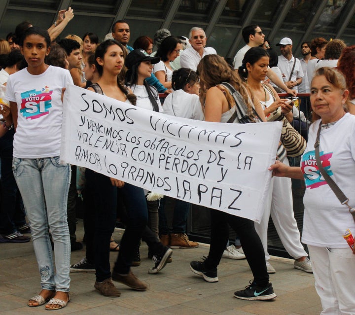 Yenny Hernandez and Blomia Perez Alvaréz of the Network for Women Victims and Professionals hold a banner that reads, "We are victims and we overcame obstacles of violence with forgiveness and love. We will achieve peace" while joining pro-peace festivities ahead of an October 7 march in Medellín.