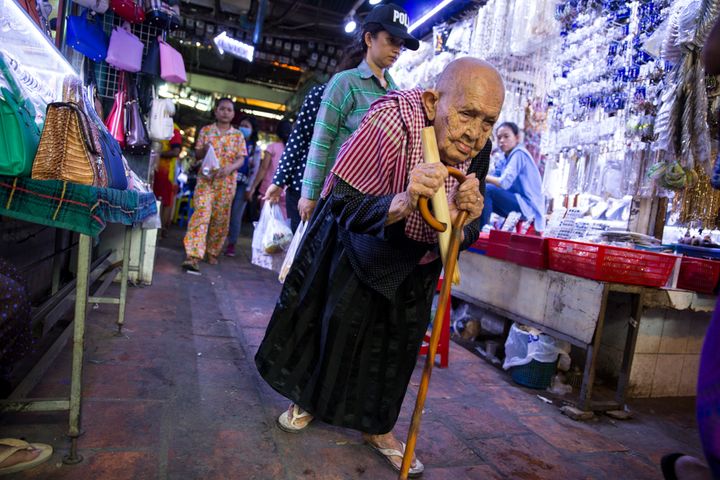 An elder woman wanders the market stalls