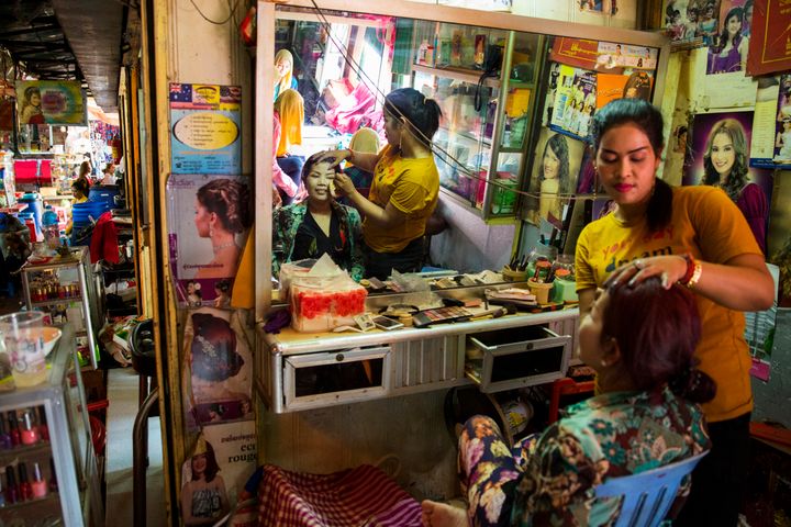 A woman gets primped at a beauty salon in the market