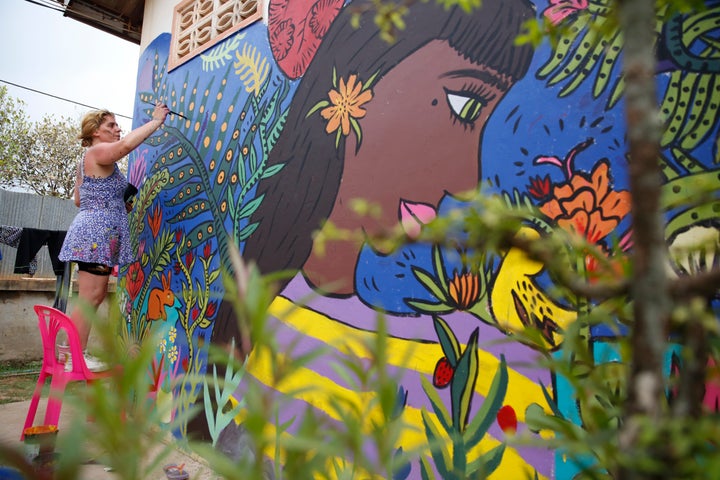 Famous artist Magda Love painting a mural on one of the buildings at AFESIP