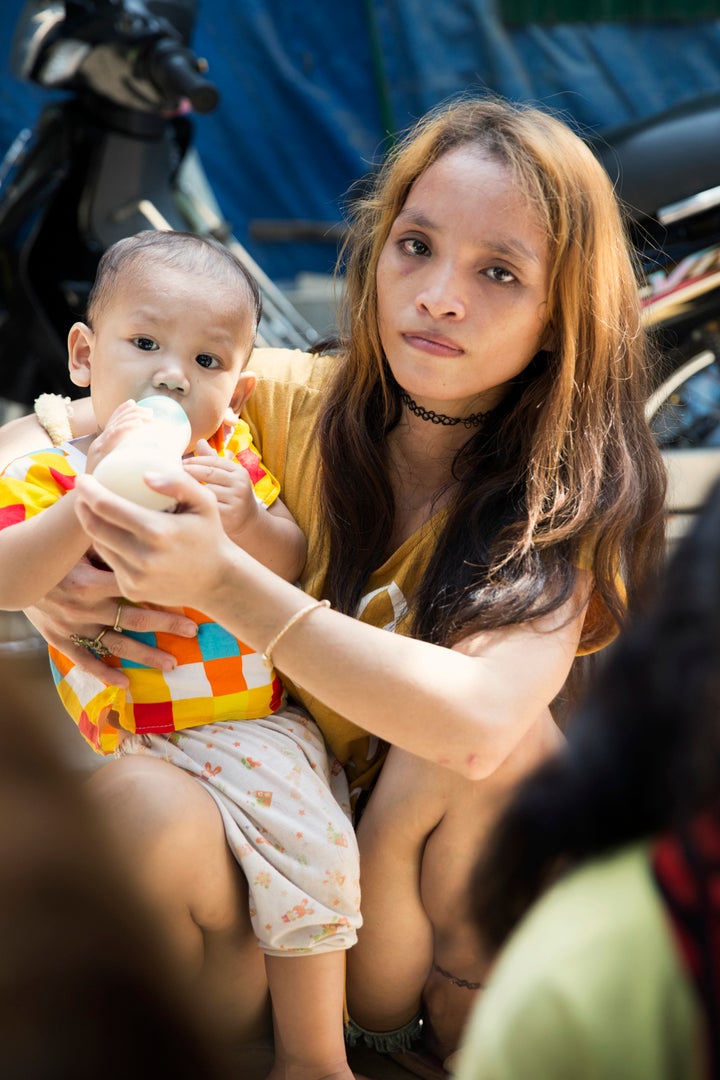 A woman sits quietly waiting for us to give her and her baby rice