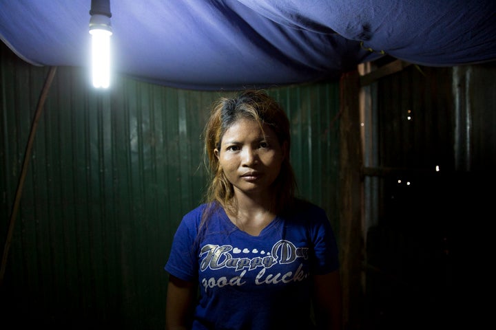 One of the brothel women poses for me under the fluorescent light of her empty room