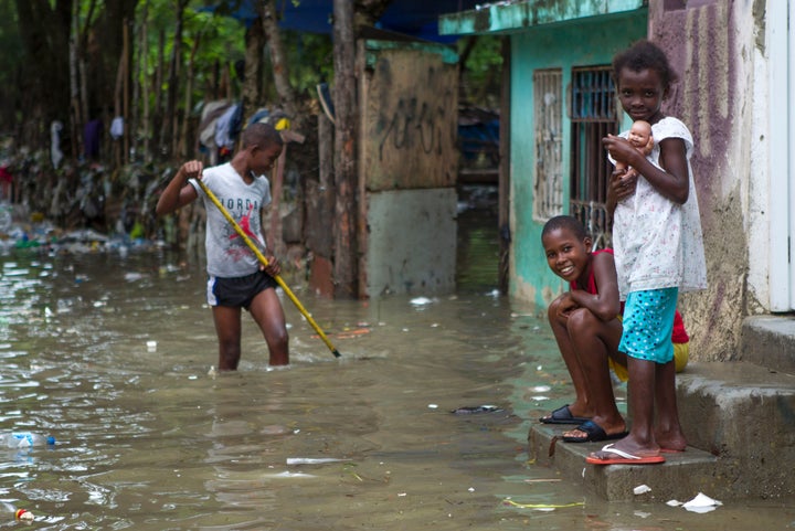 Children are pictured in the flooded neighborhood of La Puya, in Santo Domingo, on Oct. 4, 2016, after Hurricane Matthew through Hispaniola, the island that the Dominican Republic shares with Haiti.