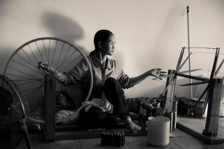 A woman weaving silk in fashion designer, Eric Raisina's design studio