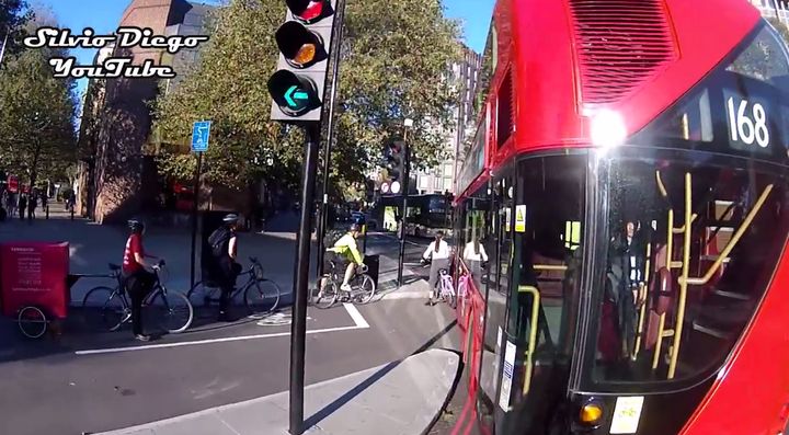 TfL is investigating after video showed this bus nudging a cyclist, seen left