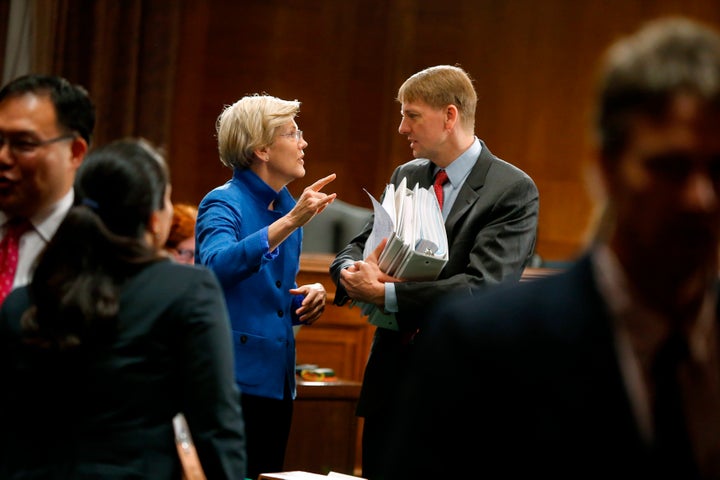 Sen. Elizabeth Warren (D-Mass.) talks with CFPB Director Richard Cordray (R) after he testified about Wall Street reform on Capitol Hill on Sept. 9, 2014.