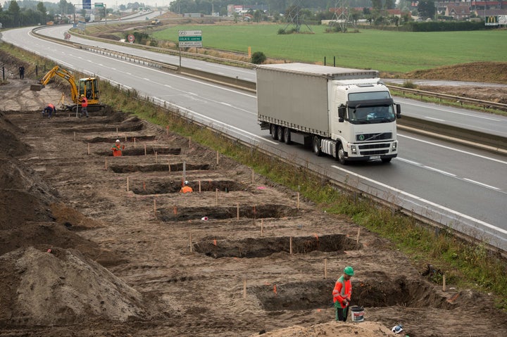 Workers dig foundations of a wall near the "Jungle" migrant camp along the road leading to the harbor of Calais in north