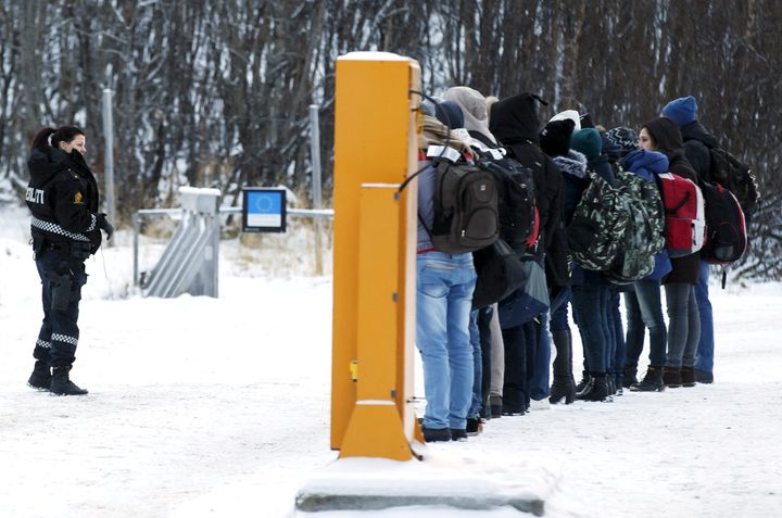 Migrants receive instructions from a Norwegian police officer at the Storskog border crossing station near Kirkenes, after crossing the border between Norway and Russia on Nov. 16, 2015.