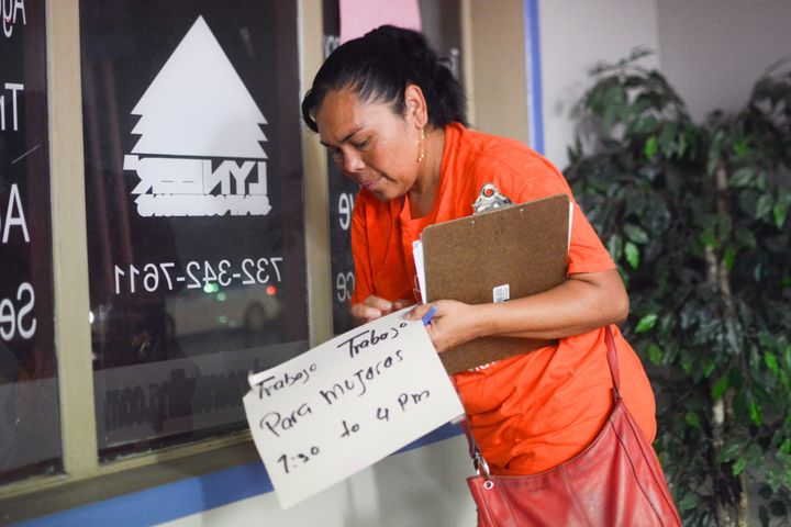Reynalda Cruz removes a New Jersey temp agency window sign that reads, “Trabajo Para Mujeres,” or “Work for Women.” Cruz was a temp worker for many years before joining New Labor, a workers advocacy group. 