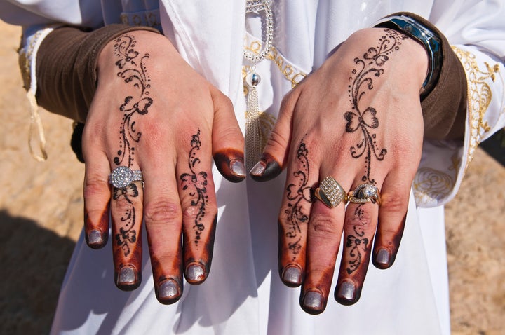 Recently married Hergueme Takwa shows off her hennaed hands in Tozeur, Tunisia.