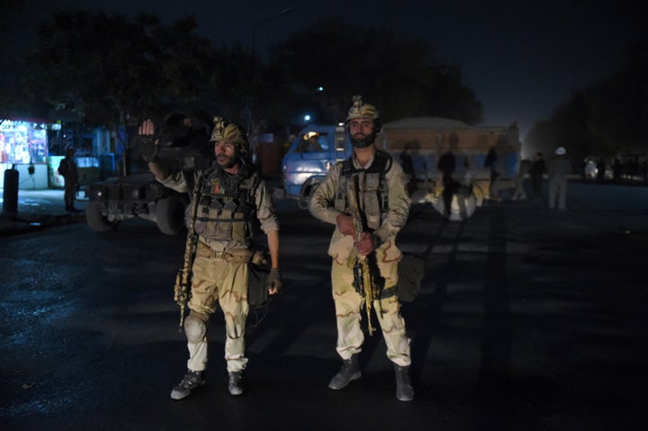 Afghan security personnels stands as they keep watch near the site of an attack by gunmen inside the Kart-e- Sakhi shrine in Kabul on October 11, 2016.