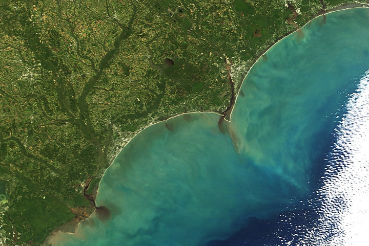 Sediment-rich floodwaters pour from rivers in North and South Carolina.