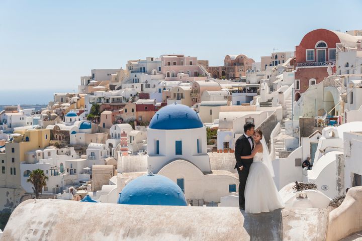 A married couple poses in Santorini, Greece.