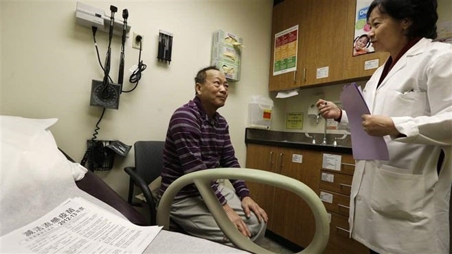 A Vietnamese-speaking patient receives a checkup in Seattle. A new federal rule requires hospitals and other health care providers to offer interpreters to many non-English speakers.