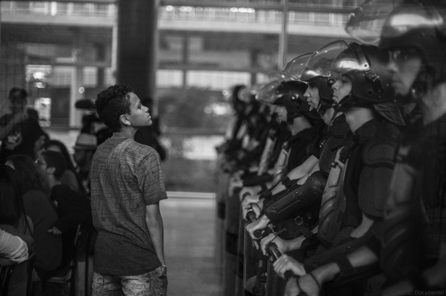 A student stares back resiliently at police officers inside the Paula Souza Center where the administration of the Sao Paulo