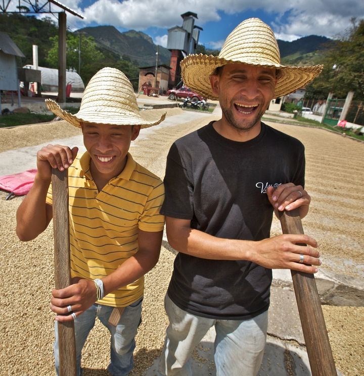 Luis Escobar Lara and Victor Samuel Galix working at the coffee drying patio at COCAOL, a fair trade coffee producer in Honduras. 
