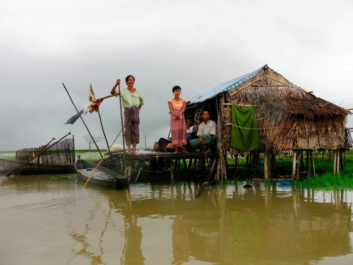 People look out from their hut, built of tarpaulin and bamboo, located on the swamp of Pay Kunhasay village, Kawhmu Township October 28, 2008. Six months after Cyclone Nargis slammed into army-ruled Myanmar, killing more than 130,000 people, many in the worst-hit Irrawaddy delta continue to rely on handouts to stay alive.