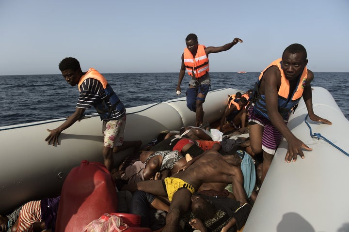 Migrants step over dead bodies while being rescued by members of Proactiva Open Arms nongovernmental organization in the Mediterranean Sea, some 12 nautical miles north of Libya, on Oct. 4.