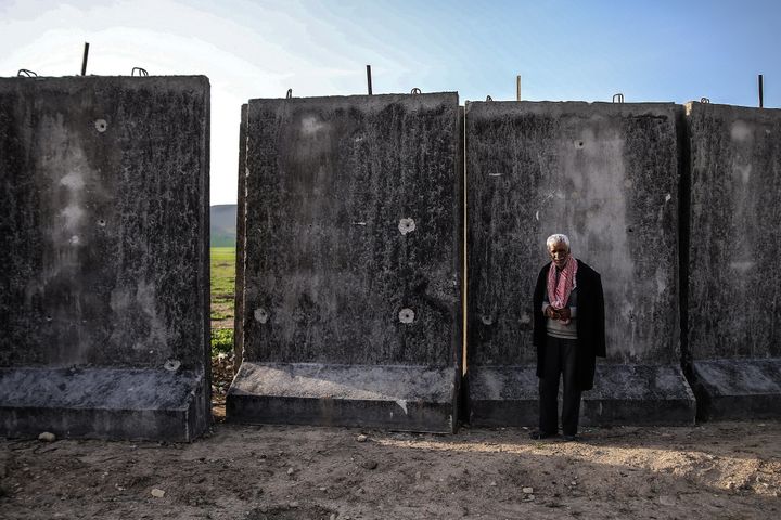 A local man stands in a village by a wall being built along the Syrian-Turkish border on March 9.