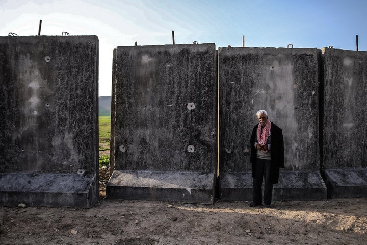 A local man stands in a village by a wall being built along the Syrian-Turkish border on March 9.