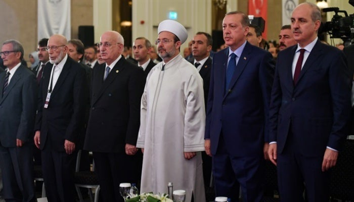 Turkey's Religious Affairs President Mehmet Gormez stands next to President Erdogan at an extraordinary meeting of Religious