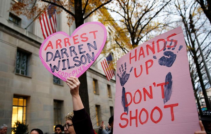 Protestors hold signs as they rally in 2014 against the grand jury exoneration of Officer Darren Wilson for the shooting and killing of Michael Brown in Ferguson, Missouri. The city is still struggling to fill open jobs in its police force.