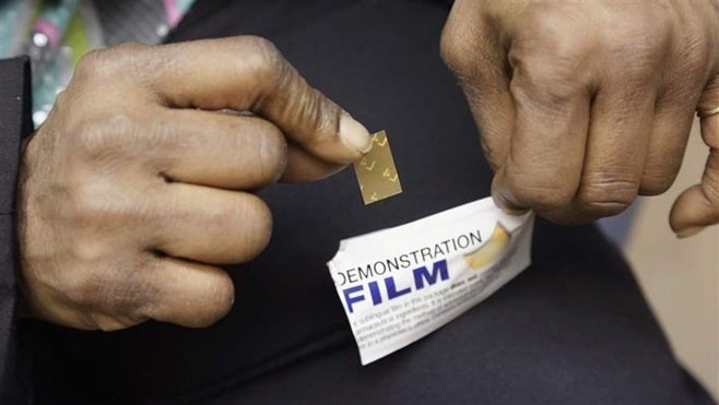 A recovering heroin addict holds a dose of Suboxone, the most commonly sold form of buprenorphine, one of three opioid addict