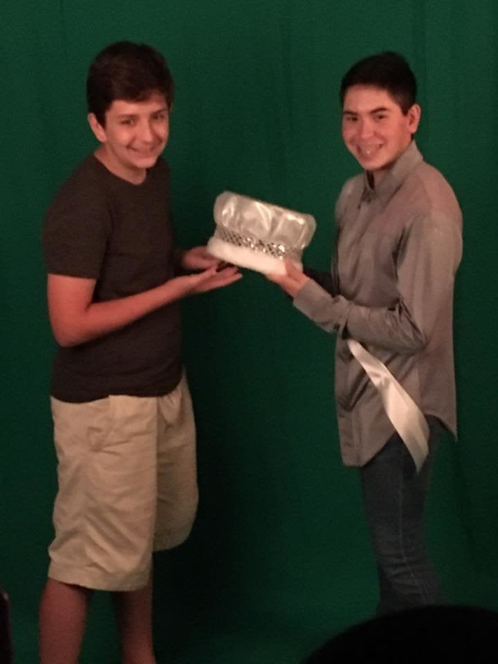 Nick's brother, Noah (L), posing with his brother's crown.