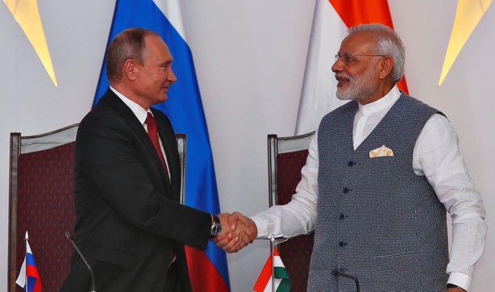 Russian President Vladimir Putin (L) shakes hands with India's Prime Minister Narendra Modi during exchange of agreements eve