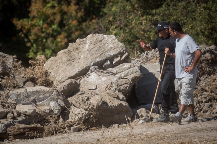 A South Yorkshire Police officer and a workman discuss moving rubble at a new second search site approximately 1km from the farmhouse search site of the missing toddler.