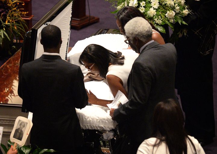 A family member leans into the casket of Keith Lamont Scott Sr., to give him a kiss.