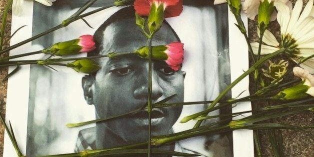 Flowers were strewn across a picture of Kalief Browder during a memorial service and protest over his death in New York City.