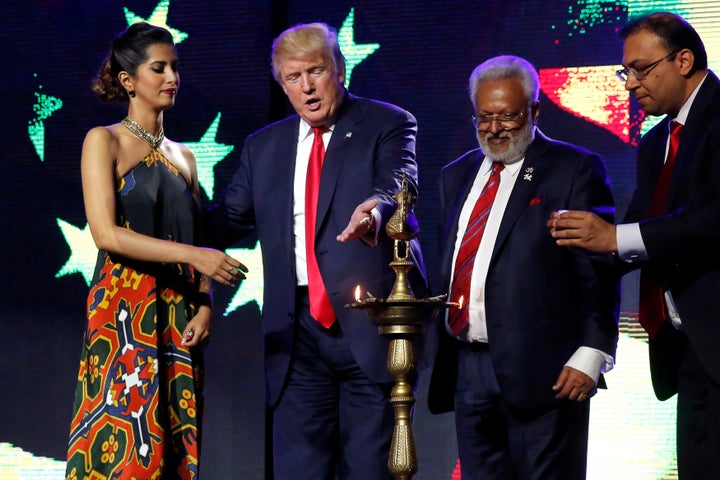 Republican presidential nominee Donald Trump enlists the help of Republican Hindu Coalition Chairman Shalli Kumar (2nd R) and others to light a ceremonial diya lamp before he speaks at a Bollywood-themed charity concert put on by the Republican Hindu Coalition in Edison, New Jersey, U.S.