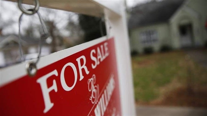 A “For Sale” sign hangs in front of a home in Atlanta. As the construction of affordable single-family houses fails to keep u