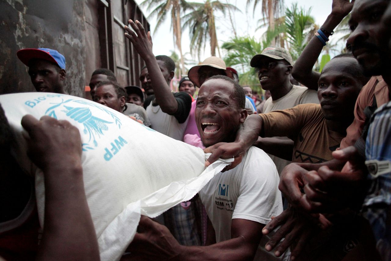 Haitians fight over a sack of rice distributed by humanitarian aid workers after Hurricane Matthew ripped through the tiny nation.