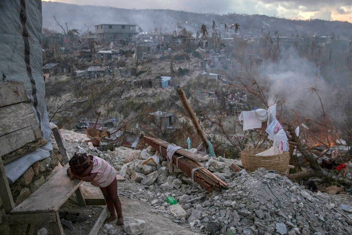 On 10 October 2016 in Jérémie, Haiti, a toddler rests near collapsed homes on top of a hill. One week after Hurricane Matthew, as schools re-open across the country, more than 100,000 children will be missing out on learning after their schools were either damaged or converted into shelters.