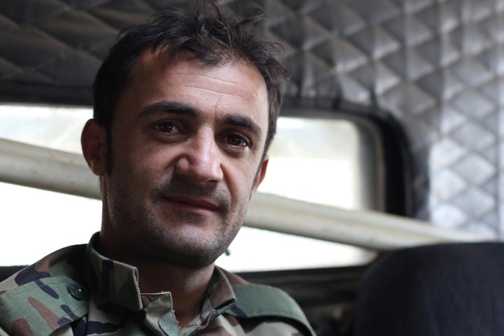 A Kurdish Peshmerga deminer sits inside of an armored, mine-resistant &ldquo;Badger&rdquo; vehicle while his colleagues defus