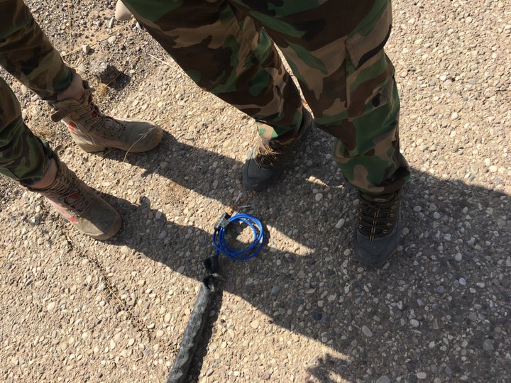 Peshmerga fighters stand next to a defused Islamic State IED meant to explode when a vehicle or person put pressure on it. It was hidden next to a trench on a main road in Hasan al Sham. 