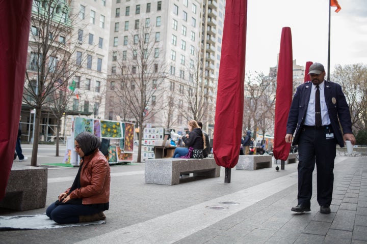 A woman prays near New York City's Metropolitan Museum of Art.