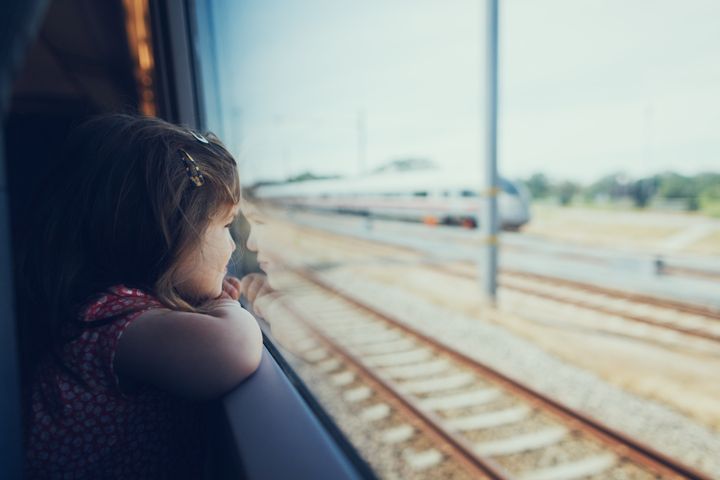 Young girl looking through the window in the train on the move Jekaterina Nikitina via Getty Images