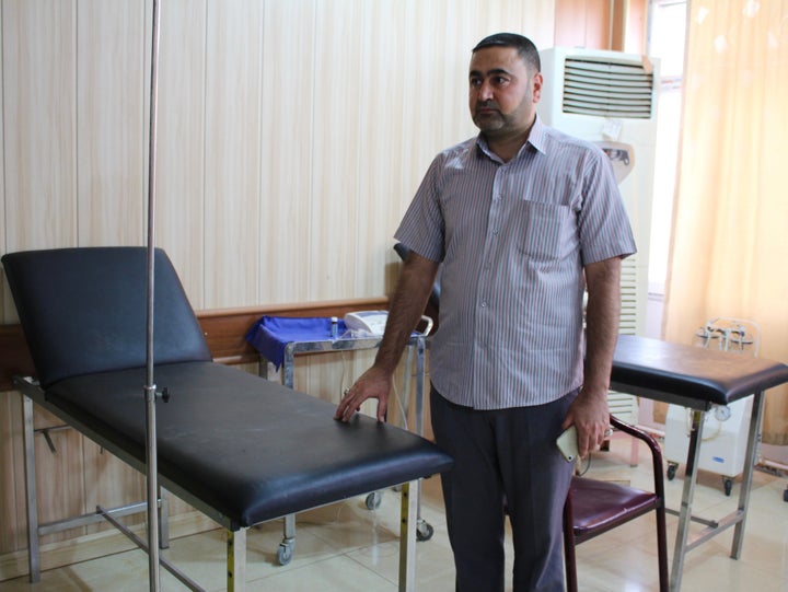 A nurse at the small medical center in Taza, Iraq, stands next to the hospital bed where he tried to save Fatima's life in March.