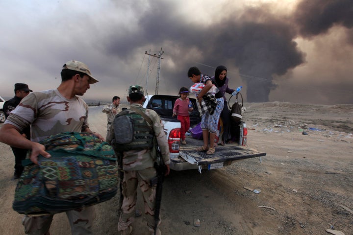 Displaced people who are fleeing from clashes arrive in Qayyarah, during an operation to attack Islamic State militants in Mo