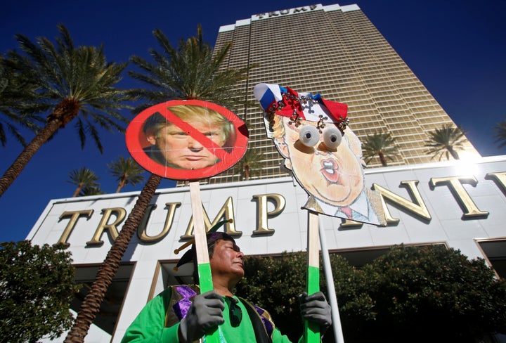 A protester holds signs during the Wall of Tacos demonstration.